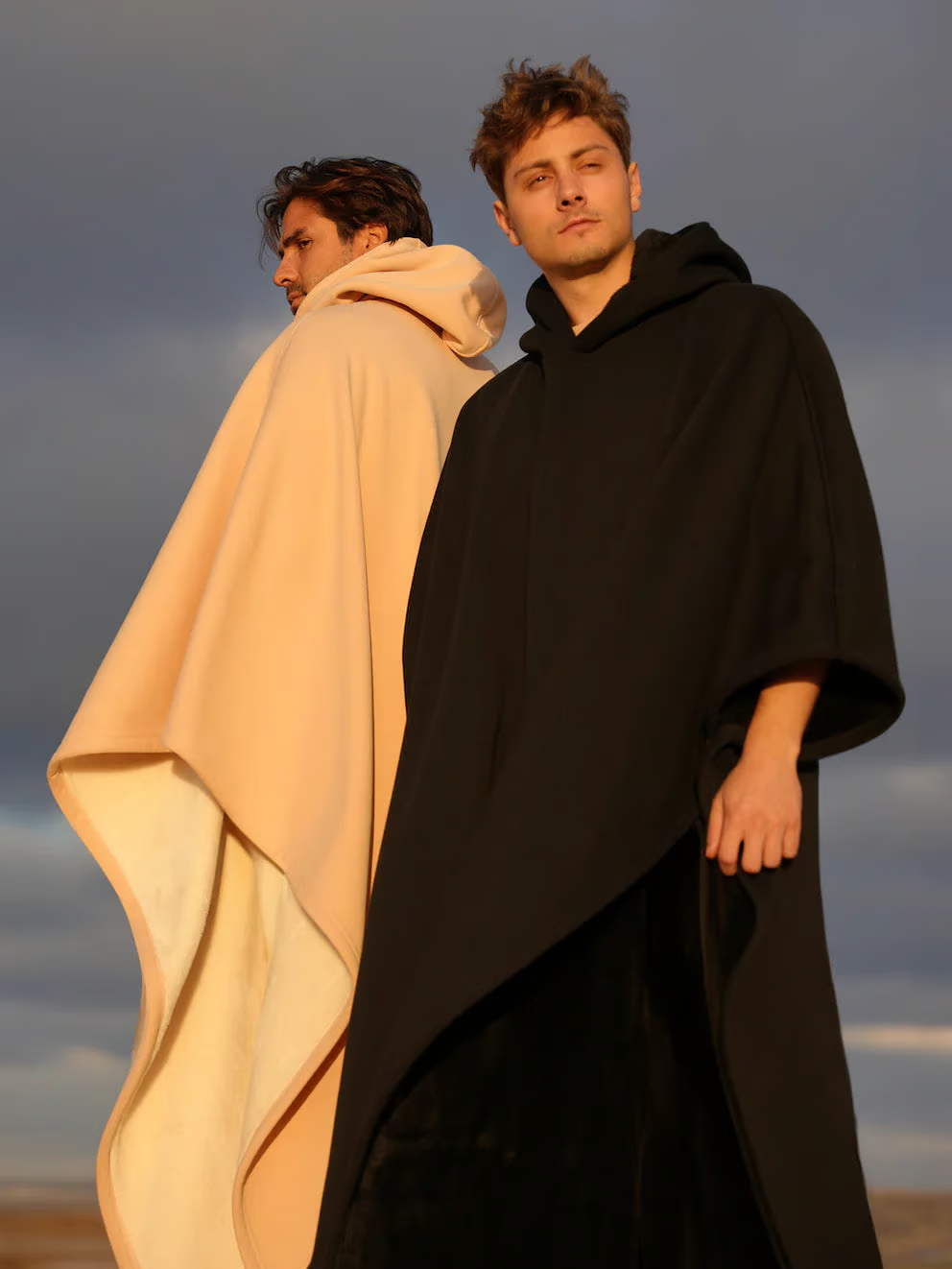 Two men in oversized hooded ponchos