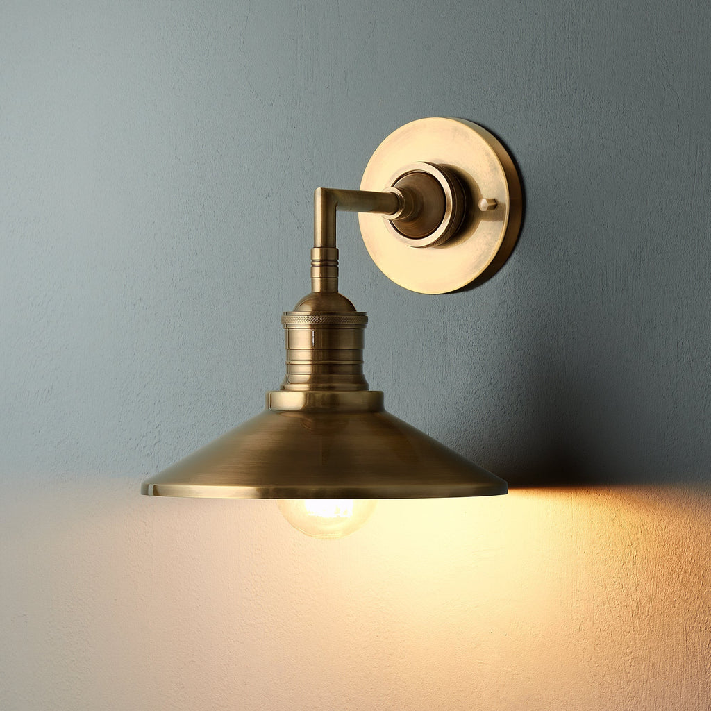 Lyra vägglampa — antik mässing, konformad skärm, synlig glödlampa