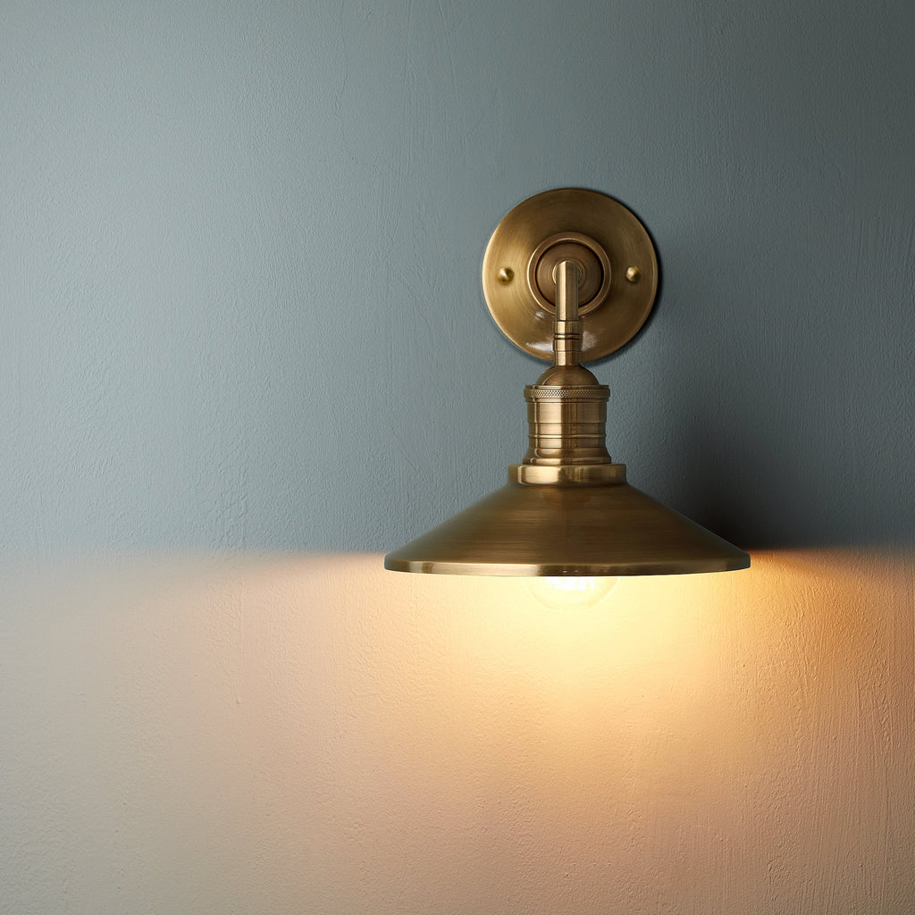 Lyra vägglampa — antik mässing, konformad skärm, synlig glödlampa